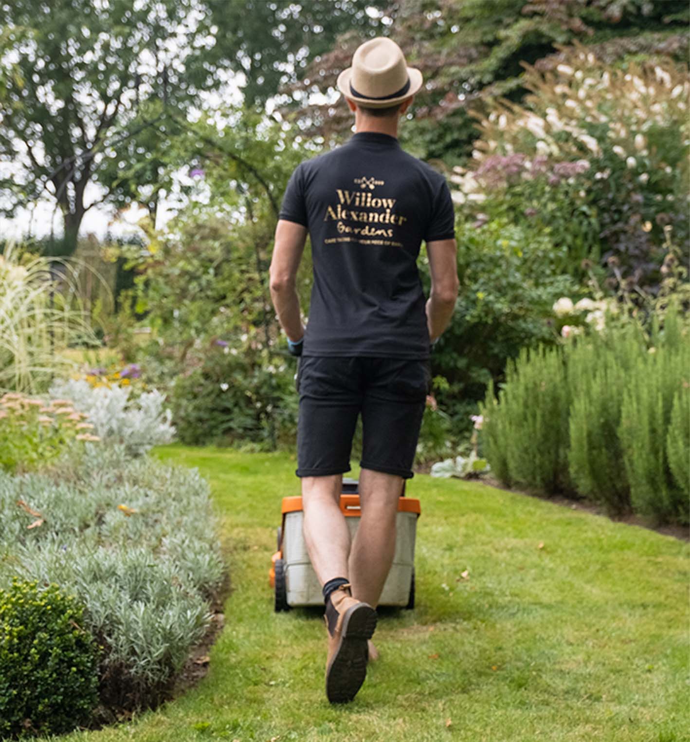 One of the Willow team mowing a garden