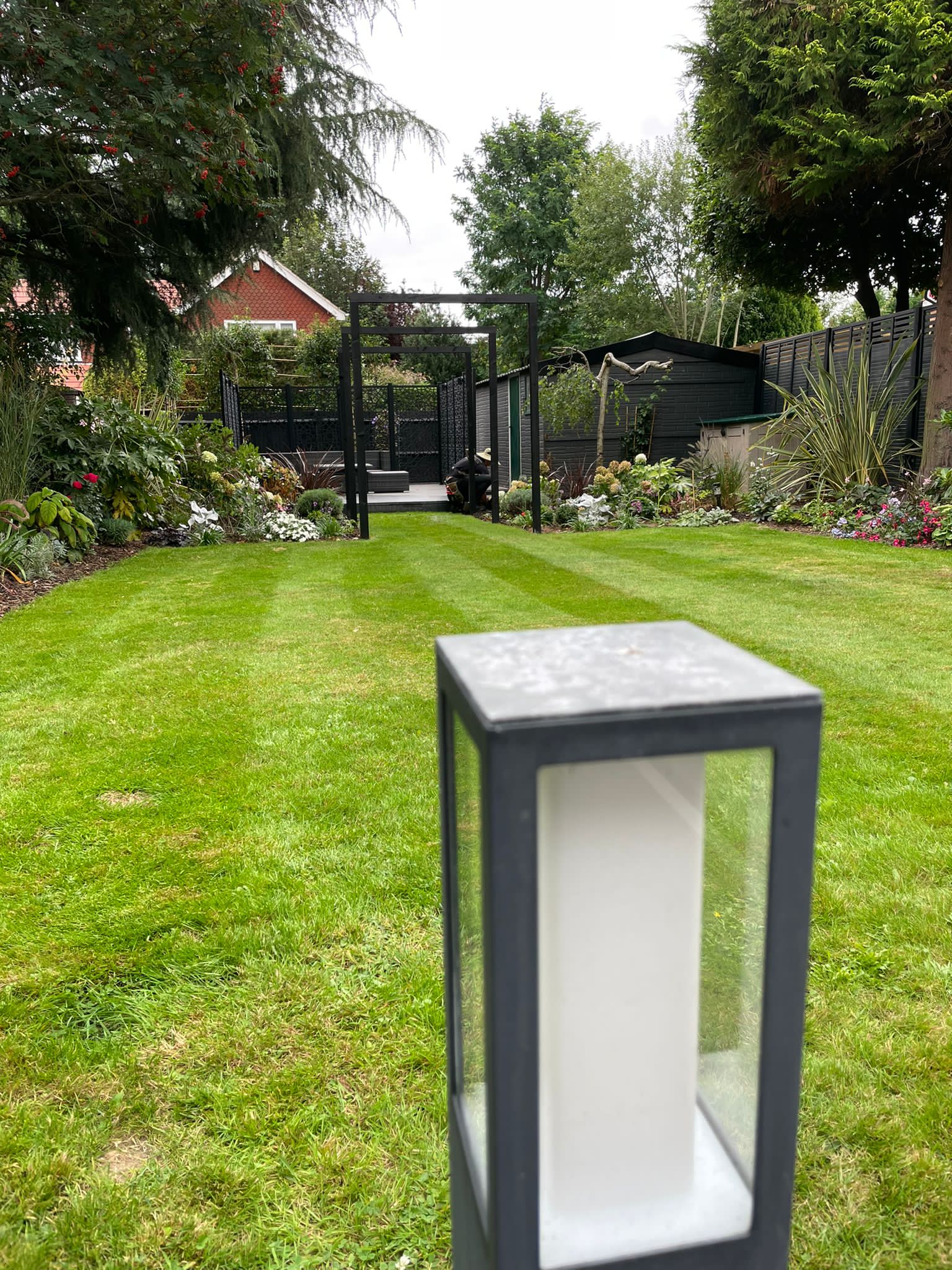 A dark grey steel lightbox frame on a well maintained garden lawn designed by WIllow Alexander
