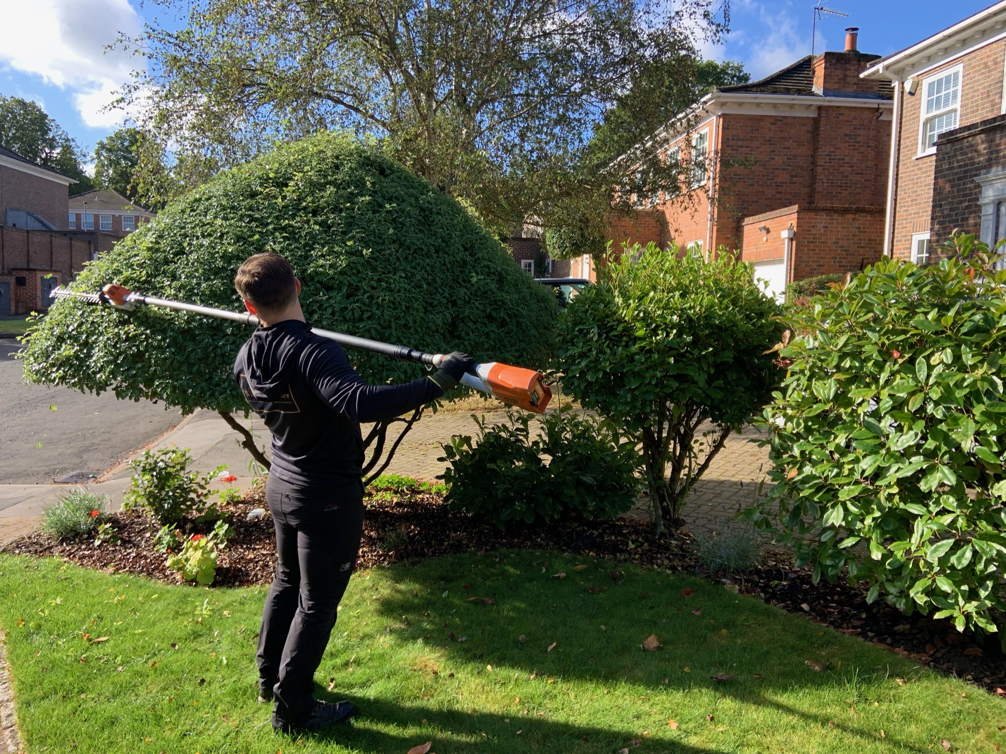 One of the Willow Alexander Gardens team trimming a Hedge
